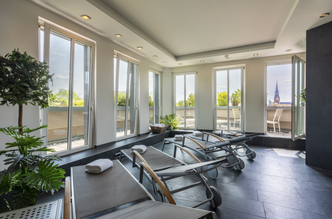 Ein entspannter Wellnessraum mit Ausblick über die Dächer Berlins.